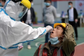 Một công nhân tại Vũ Hán được lấy mẫu xét nghiệm COVID-19. Ảnh: REUTERS