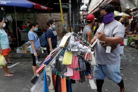 Người dân thủ đô Manila (Philippines) đeo khẩu trang và giữ khoảng cách tại một khu chợ ở thành phố hôm 23-4. Ảnh: AP