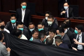 Các nghị sĩ đối lập phản đối việc ông Trần Kiện Ba (người ngồi trên bục chủ tọa) điều hành buổi họp của Ủy ban Nội vụ thuộc Hội đồng Lập pháp Hong Kong. Ảnh: SCMP