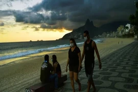 Người dân đeo khẩu trang đi dạo trên bãi biển ở Rio de Janeiro. Ảnh: AFP