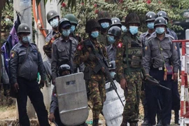 Quân đội Myanmar cầm súng kiềm chế người biểu tình ở TP Mandalay, Myanmar. Ảnh: AFP