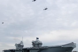 Trực thăng bay phía trên chiếc hàng không mẫu hạm mới HMS Queen Elizabeth của Hải quân Hoàng gia Anh khi nó đến Portsmouth, Anh.