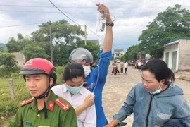 Nữ thí sinh đeo bình truyền nước trên tay đến phòng thi 