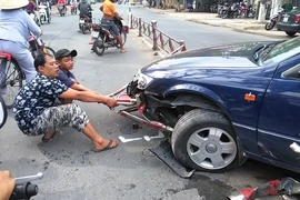 xe cán bẹp và dính luôn dải phân cách vào gầm xe (ảnh HÀ HUY)
