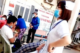 Một ông thản nhiên hút thuốc tại khu vực Khoa Dược - BV đa khoa Củ Chi. Ảnh: TRẦN NGỌC