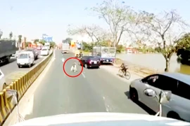 Người đàn ông giả khuyết tật nằm lê lết bên làn đường ô tô vẫy tay ăn xin. (Ảnh cắt từ clip)