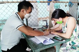 Người dân quận 12, TP.HCM nhận hỗ trợ đợt 3. Ảnh: NGUYỄN HIỀN