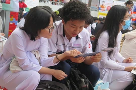 Học sinh Trường THPT Gia Định (TP.HCM) tìm hiểu và đặt câu hỏi với các trường đại học tại một ngày hội tư vấn tuyển sinh. Ảnh: P.ANH