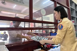 Cán bộ Phòng CSGT tỉnh Gia Lai cấp biển số xe định danh cho người dân. Ảnh: L.KIẾN