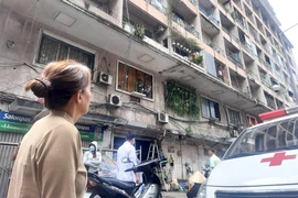 Bà Năm ngước nhìn ký túc xá Trường CĐ Kỹ thuật Cao Thắng mỗi lần đi ngang qua vì sợ bị vật gì đó rơi trúng. Ảnh: TRẦN NGỌC