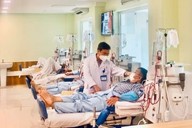 TS-BS Nguyễn Bách, Trưởng khoa Nội thận - Lọc máu BV Thống Nhất, thăm khám cho bệnh nhân. Ảnh: THẢO PHƯƠNG