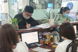 Người dân đến cơ quan BHXH TP.HCM làm thủ tục BHXH, BHYT. Ảnh: NGUYỄN HIỀN