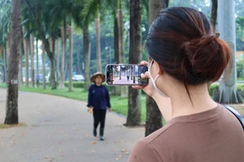 Việc dùng điện thoại quay phim, chụp ảnh tại công viên không cần phải xin giấy phép. Ảnh: TRẦN MINH 
