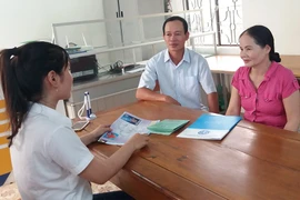 Cán bộ BHXH Việt Nam đang tư vấn về BHXH tự nguyện cho người dân. Ảnh: VIẾT LONG