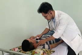 BS Ngô Minh Nhật đang khám bệnh tại Trạm y tế xã Bình Hưng, huyện Bình Chánh, TP.HCM. Ảnh: TRẦN NGỌC