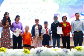 Bà Nguyễn Phương Linh và ông Huỳnh Tấn Đạt trao giấy khai sinh cho một số trẻ em có hoàn cảnh đặc biệt. Ảnh: VÕ THƠ