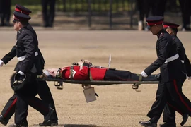 Vệ binh Anh được đưa lên cáng sau khi ngất xỉu. Ảnh: AFP