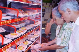 Thịt ngoại tràn ngập thị trường. Trong ảnh: Khách hàng chọn lựa mua thịt trong siêu thị. Ảnh: QH