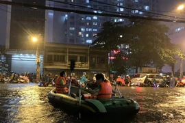 Mưa kỷ lục: Dân bơi thuyền ra phố để mang xe máy vào nhà
