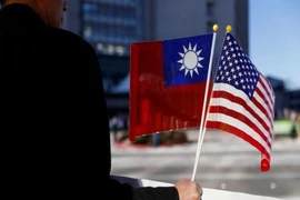 Một người cầm cờ Đài Loan và Mỹ. Ảnh: REUTERS
