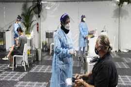 Nhân viên y tế Úc xét nghiệm cho du khách tại sân bay Sydney. Ảnh: REUTERS