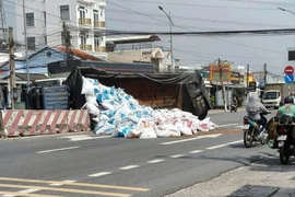 Né xe đạp điện băng qua đường, xe tải lật ngang Quốc lộ 1A