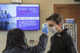 Kiểm tra nhiệt độ tại một bến phà chở khách ở Thượng Hải (Trung Quốc) ngày 30-1. Ảnh: BLOOMBERG