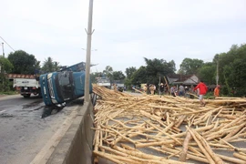 Lật xe gỗ keo, người dân giúp tài xế gom gỗ