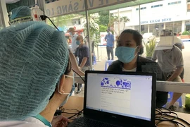 Nhân viên y tế hỗ trợ người dân khai báo y tế. Ảnh: HL
