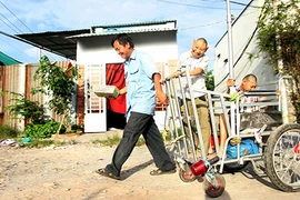 Một ngày của người cha bán kẹo mút nuôi hai đứa con bại não