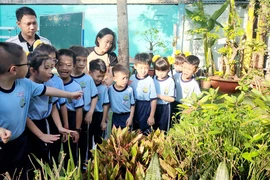 Các phụ huynh tham dự tiết học mở cùng con tại vườn trường của Trường Tiểu học Lê Văn Thọ (quận Gò Vấp, TP.HCM). Ảnh: NGUYỄN QUYÊN