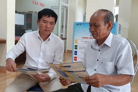 Nhân viên BHXH Việt Nam tuyên truyền người dân tham gia BHXH tự nguyện. Ảnh: V.LONG