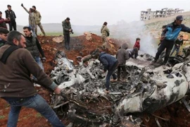 Người dân tập trung quanh mảnh vỡ chiếc trực thăng của chính phủ Syria bị bắn rơi ở tây Aleppo, Syria. Ảnh: AP