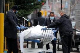 Các nhân viên đẩy một thi thể bên ngoài bệnh viện Brooklyn ở New York (Mỹ). Ảnh: REUTERS