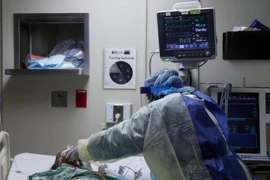 Y tá chăm sóc một bệnh nhân COVID-19 tại phòng chăm sóc tích cực ở Chicago, bang Illinois (Mỹ). Ảnh: REUTERS