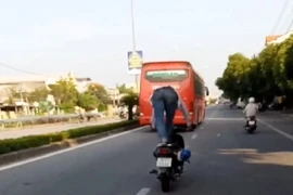 Người đứng trên yên xe máy khi chạy xe bị phạt tiền