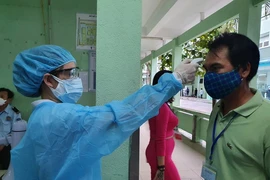 Bệnh viện Đà Nẵng tiến hành kiểm tra thân nhiệt cho người dân. Ảnh: Tâm An