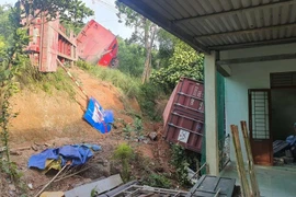 Xe đầu kéo lật trên Quốc lộ, thùng container lăn vào tường nhà dân