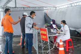 Người dân vẫn phải đội mưa để khai báo y tế khi ra vào thành phố Hà Nội