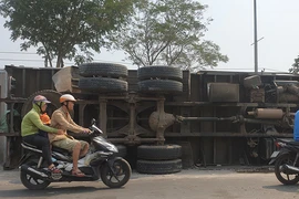Ô tô tải chở sắn lật vào làn xe máy ở Hóc Môn