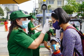 Người dân và du khách tham quan đường hoa Nguyễn Huệ (TP.HCM) được đo thân nhiệt kĩ càng. Ảnh: NGUYỄN TRÀ