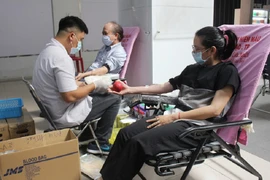 Bác sĩ đang thực hiện lấy máu của người hiến máu. Ảnh: TRƯỜNG GIANG