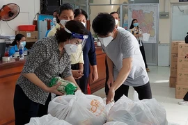 Chủ tịch Ủy ban MTTQ TP HCM Tô Thị Bích Châu kiểm tra nhu yếu phẩm trước khi chuyển đến người dân ở huyện Nhà Bè. Ảnh: UBMTTQVN TP.HCM cung cấp