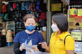 Tiểu thương chợ Bến Thành, quận 1, TP.HCM được tư vấn quyền lợi khi tham gia BHXH tự nguyện. Ảnh:NGUYỄN HIỀN