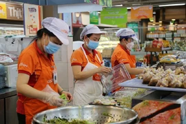 Nhân viên Siêu thị Co.opXtra Tân Phong (quận 7, TP.HCM) tất bật làm việc để phục vụ nhu cầu mua sắm của người dân. Ảnh: HOÀNG GIANG