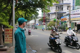 Một dân quân tự vệ đang làm nhiệm vụ điều tiết giao thông. Ảnh: Minh Thuận