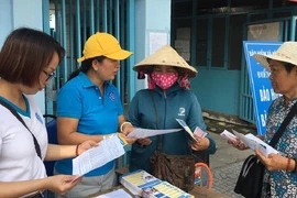 Nhân viên của cơ quan BHXH tư vấn người dân TP.HCM tham gia BHXH tự nguyện. Ảnh: NGUYỄN HIỀN 