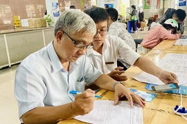 Người nhận lương hưu được hướng dẫn cài đặt ứng dụng VssID. Ảnh: CTV
