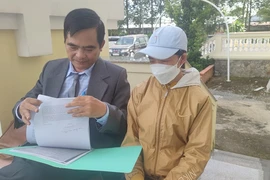 Luật sư nhận bào chữa miễn phí cho bà Dung đang trao đổi thông tin về vụ án với bà Dung. Ảnh: NGUYỄN HIỀN