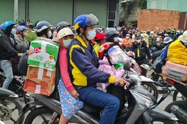 Chạy xe máy chở từ ba người về quê ăn tết có thể bị phạt. Ảnh: VŨ HỘI